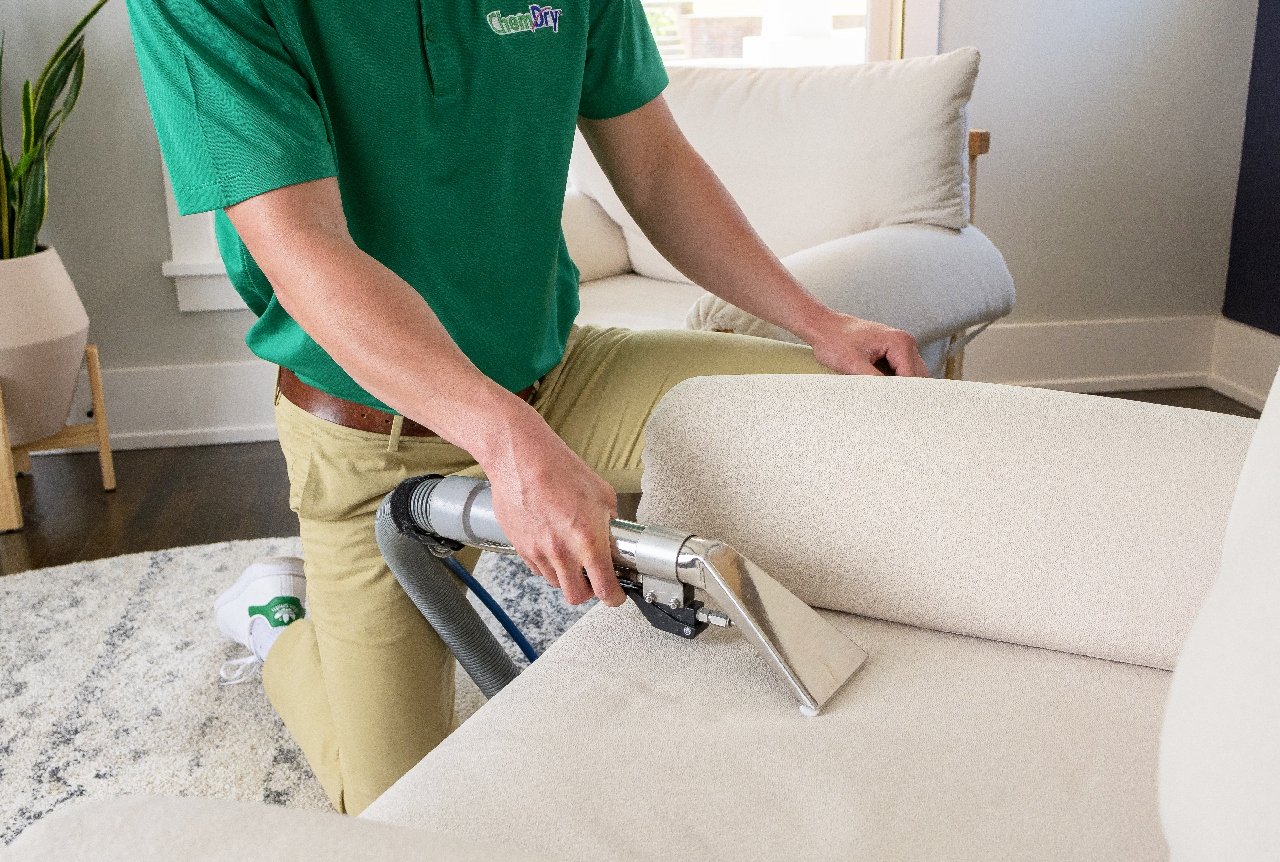 Chem-Dry technician cleaning a fabric chair with professional upholstery cleaning equipment